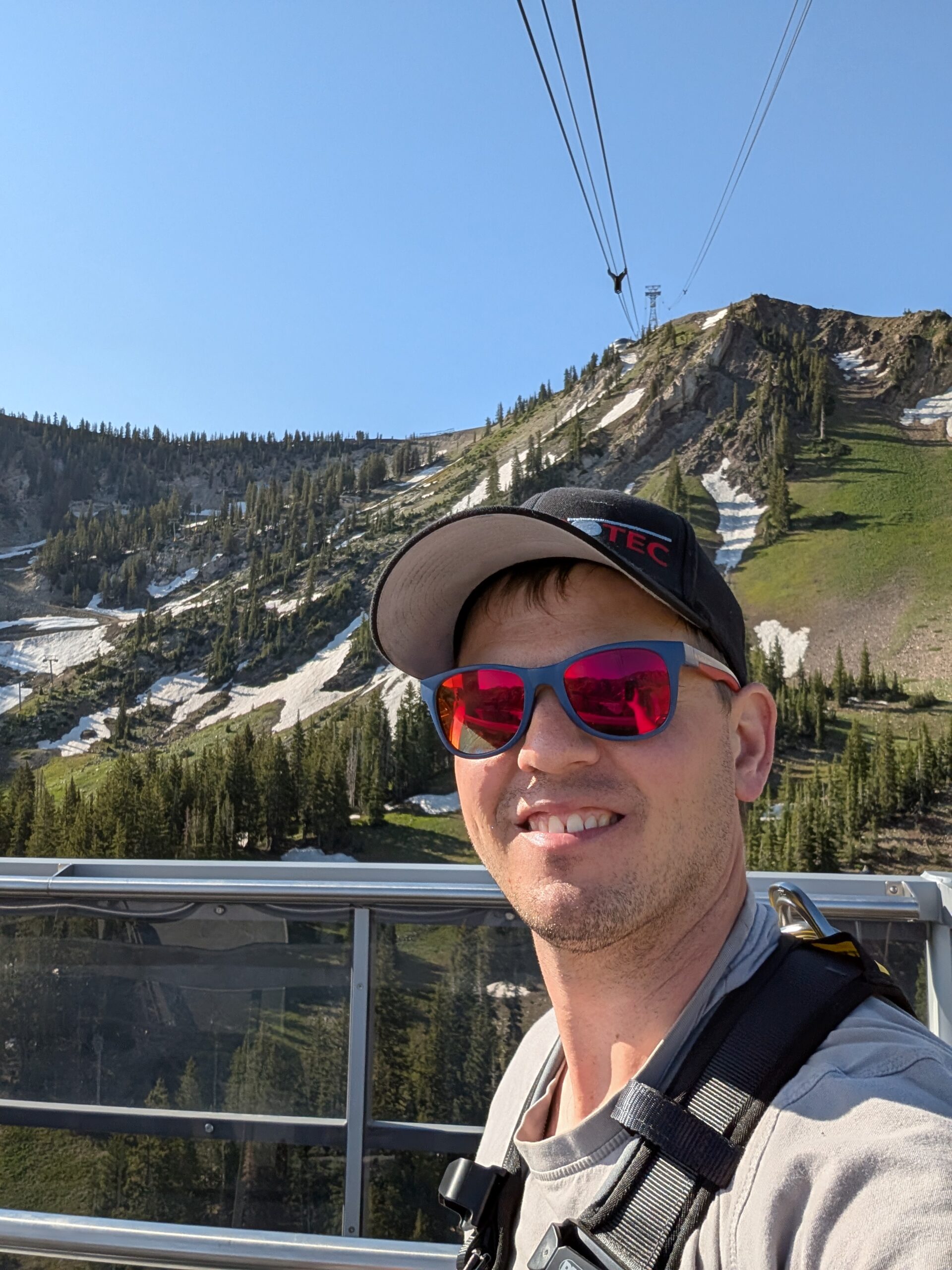 Sebastian im Einsatz bei der Seilbahnprüfung in Utah Seilbahnprüfung in Utah: ROPESYS-Techniker Sebastian vor Bergkulisse mit Schnee und Seilbahn