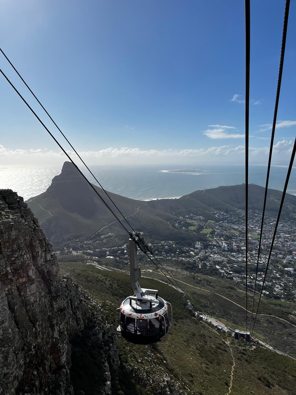 Seilbahn-Gondel am Tafelberg bei Tag. Tagaufnahme vom Tafelberg mit Blick ins Tal und der runden Gondel während der Zugseilprüfung.