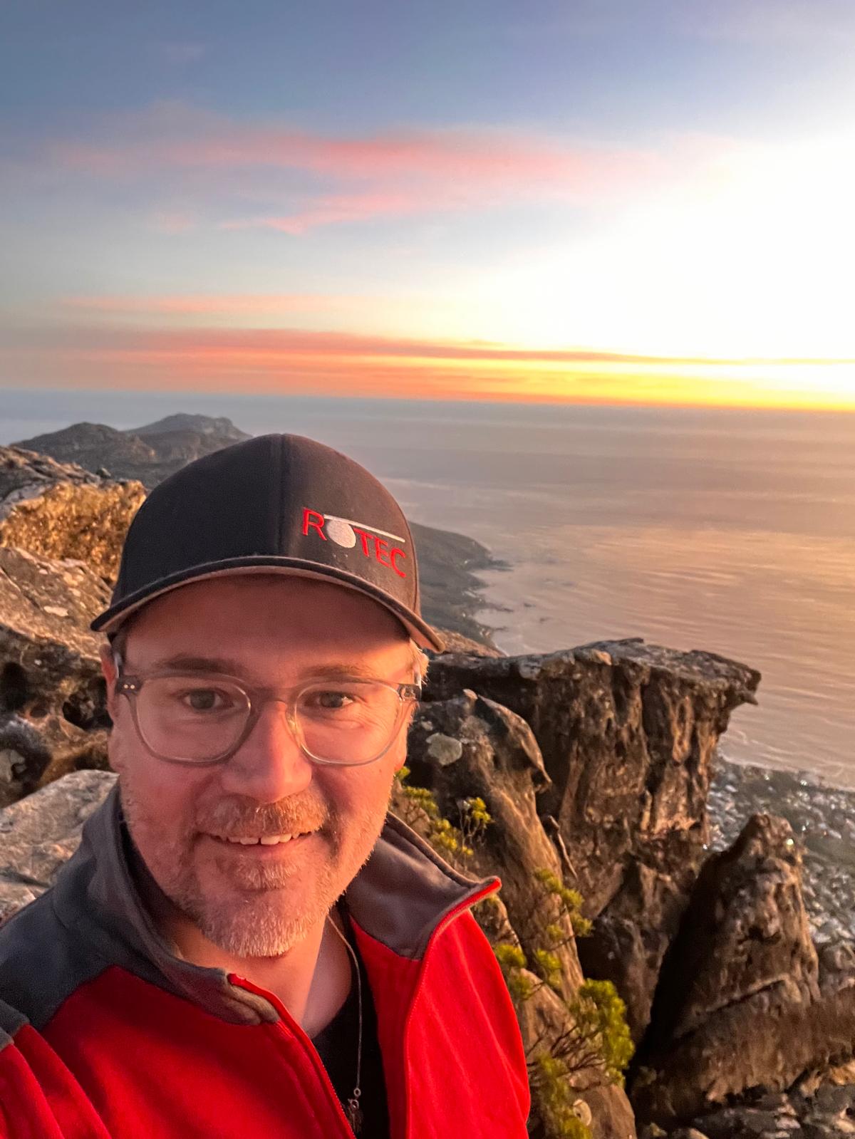 Prüfeinsatz mit Weitblick in Südafrika. Marcus Liebscher bei der Seilprüfung auf dem Tafelberg – mit Meerblick und Felsen im Abendlicht.