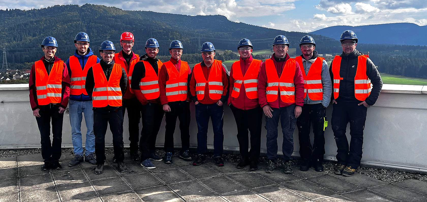 Teilnehmende des Sicherheitstrainings auf der Dachterrasse des Holcim-Gebäudes mit Blick über die grüne Hügellandschaft