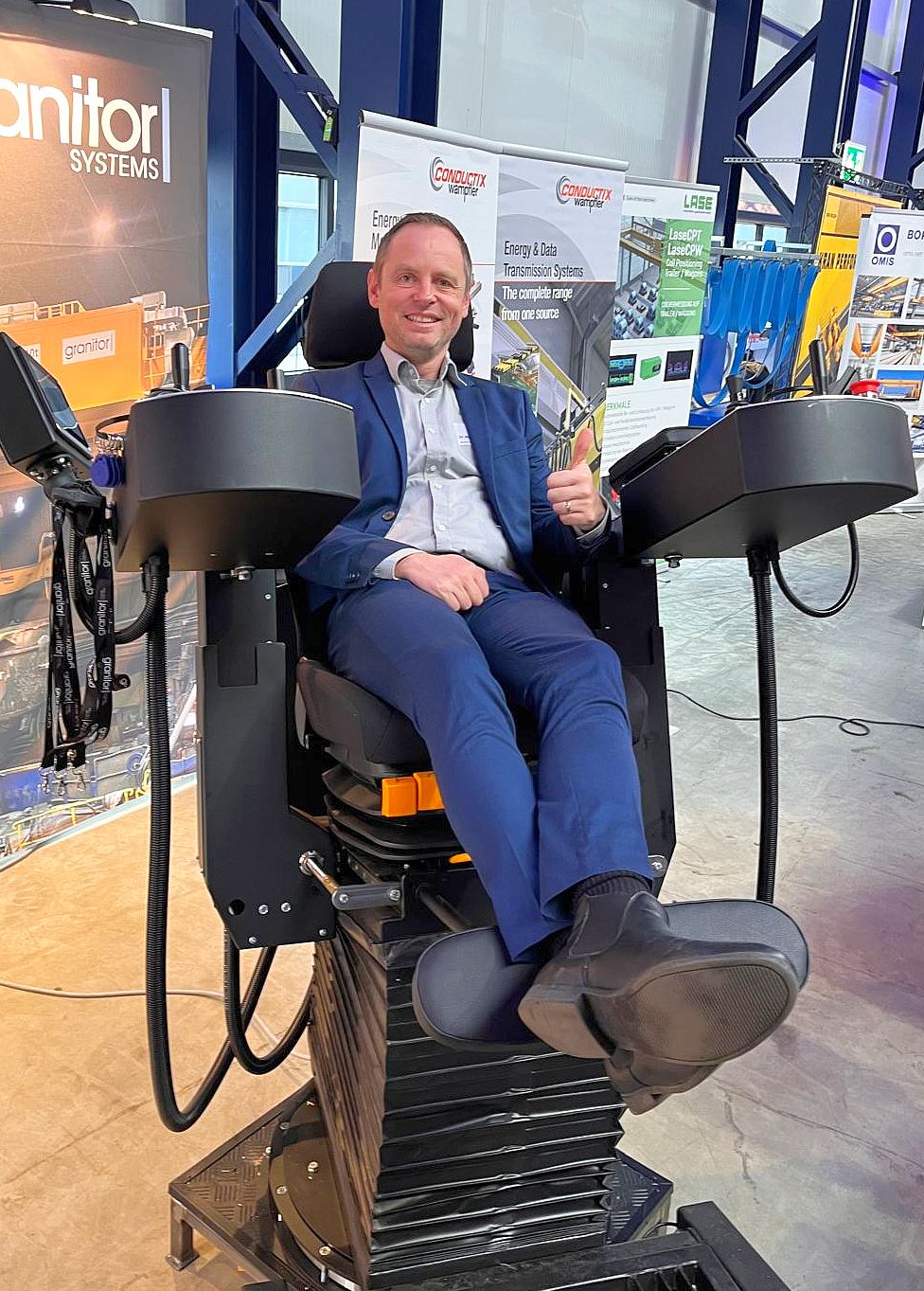 Martin sitzt lächelnd im ausgestellten Kranführersitz von BANG