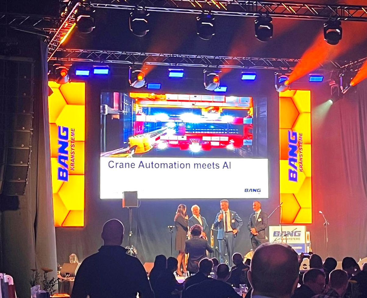 Beleuchtete Bühne der Konferenz mit Sprechern und Publikum von hinten