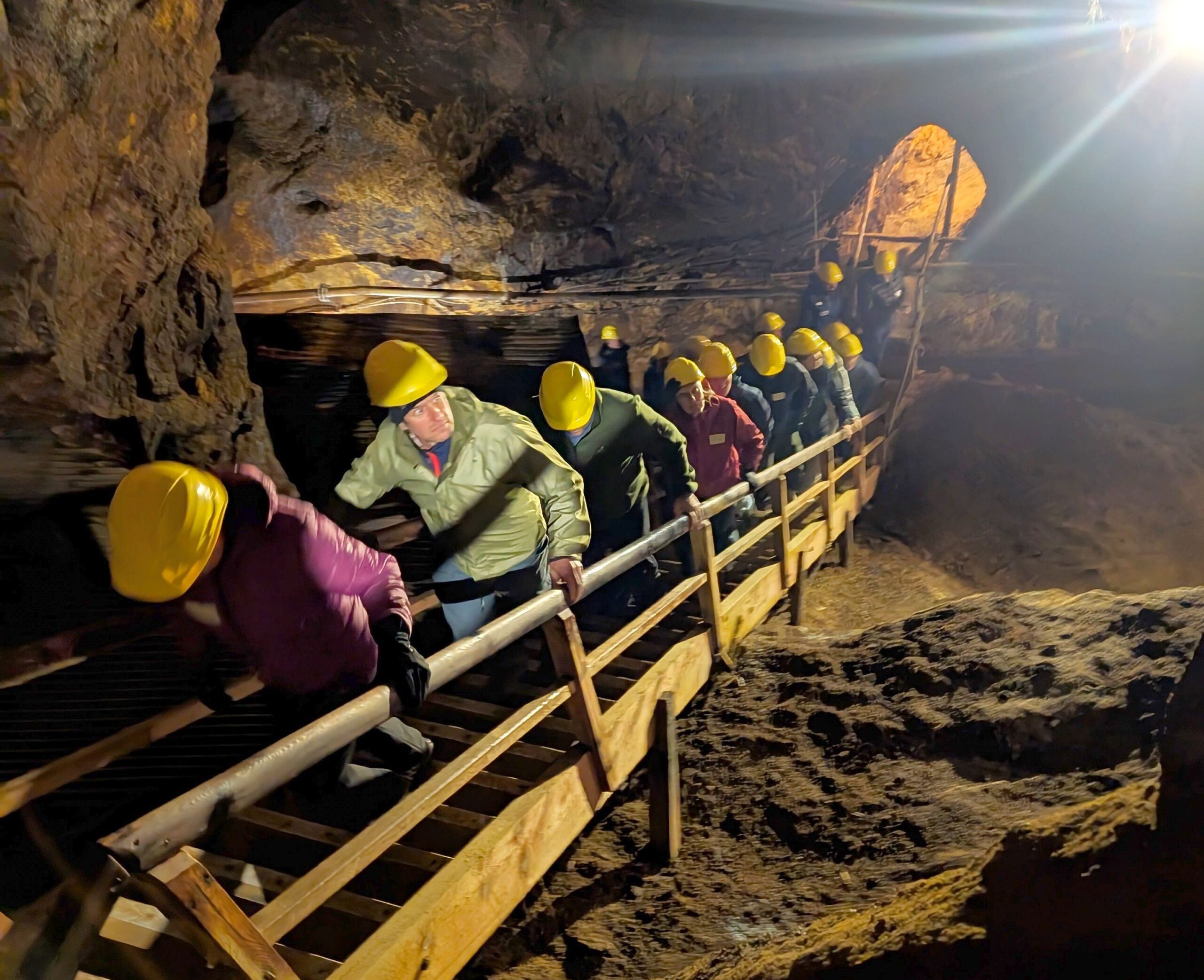 Teilnehmer der Seilbahn-Jahrestagung steigen mit Schutzhelmen im Bergwerk Silberberg eine Holztreppe hinauf