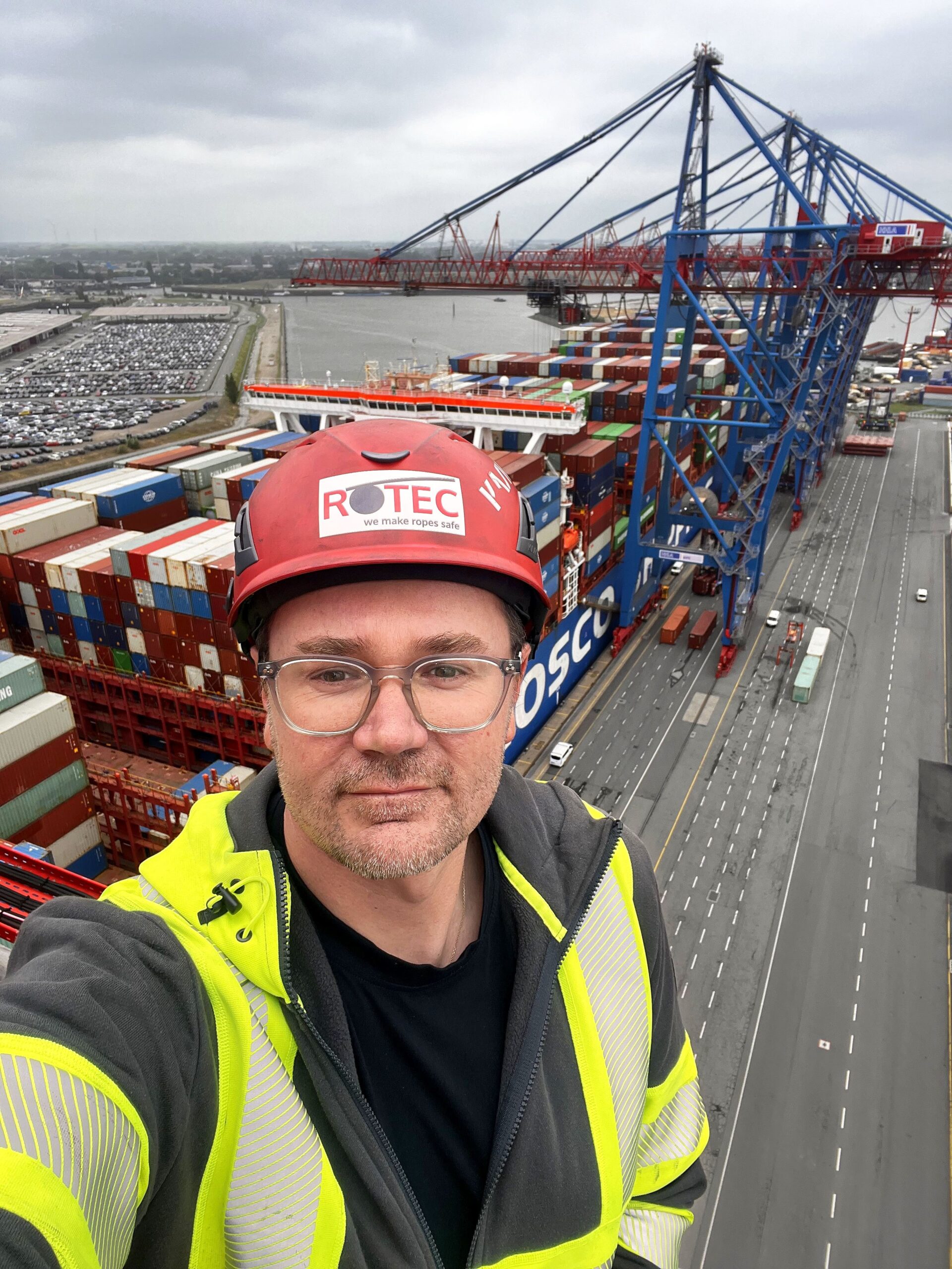 ROTEC-Mitarbeiter Marcus Liebscher mit Schutzhelm auf einem Containerkran im Hamburger Hafen.